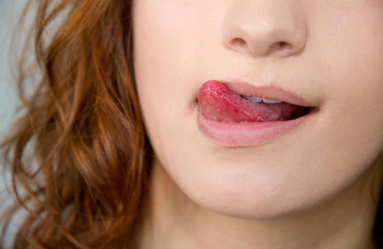 Thói quen liếm môi thường xuyên có thể gây khô môi và khiến môi dễ sậm màu